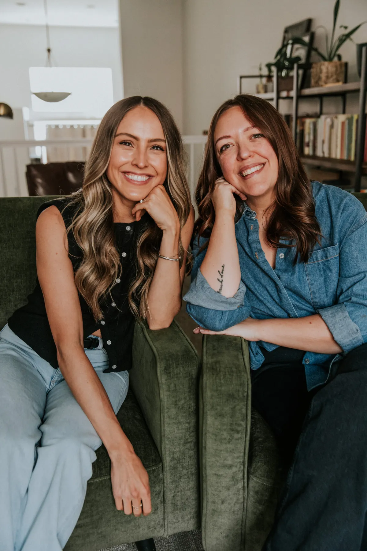 Sophie and Brandee, founders of Lazy Girl Retail, sitting together on a green velvet sofa